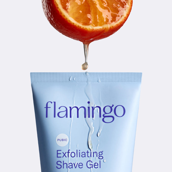Orange slice dripping juice onto the top of the tube Pubic Exfoliating Shave Gel.