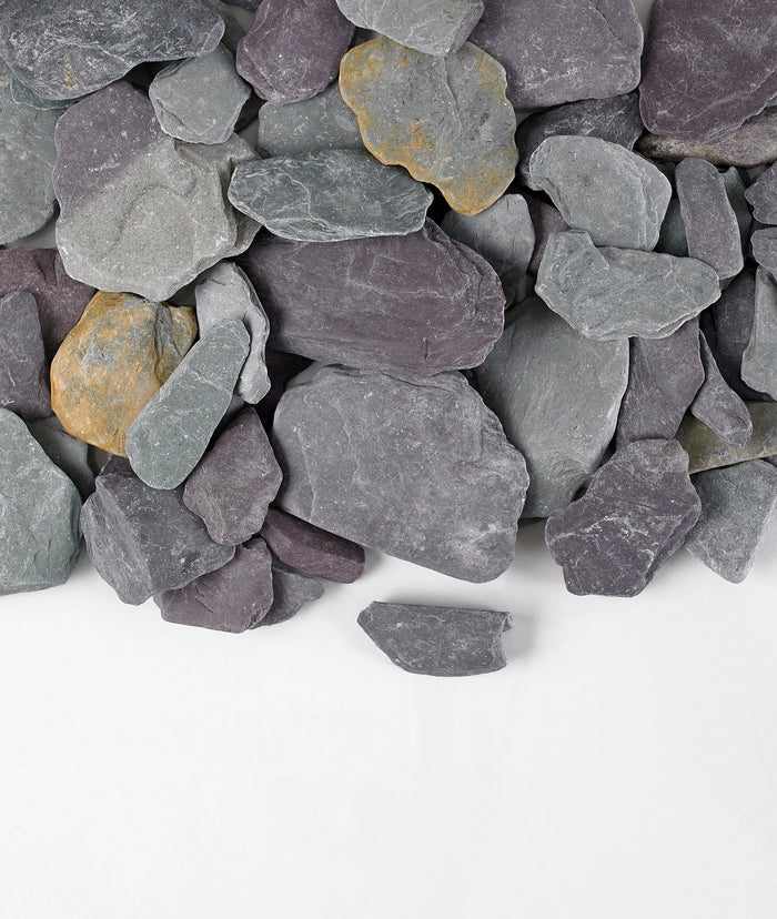 A collection of Snowdonia tumbled slate pebbles in shades of gray, blue, and green, with some flat and some rounded edges.